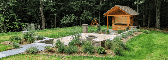 A wine bar, patio, and fire pit in a backyard with native plantings, installed by Masseo Landscape.
