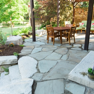 A natural bluestone patio with Rosetta Hardscape steps and built in seating, installed by Masseo Landscape in High Falls, NY.