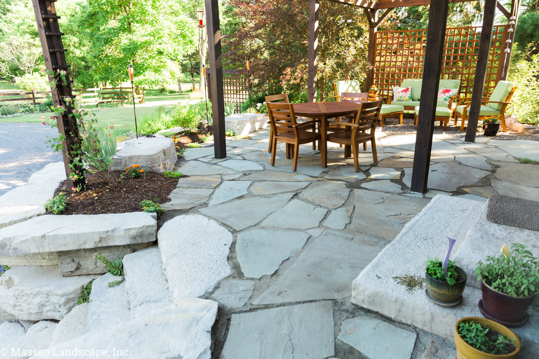 A natural bluestone patio with Rosetta Hardscape steps and built in seating, installed by Masseo Landscape in High Falls, NY.