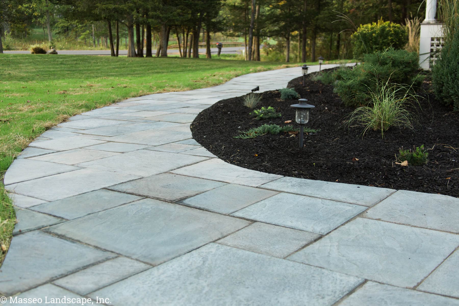 Geometric pavers cut to fit a curvilinear winding walkway layout in New Paltz, NY, designed and installed by Masseo Landscape, Inc.