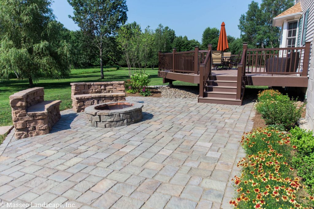 Rosetta Hardscapes patio, round fire pit, and custom-built stone benches designed and installed by New Paltz Landscapers, Masseo Landscape, Inc.