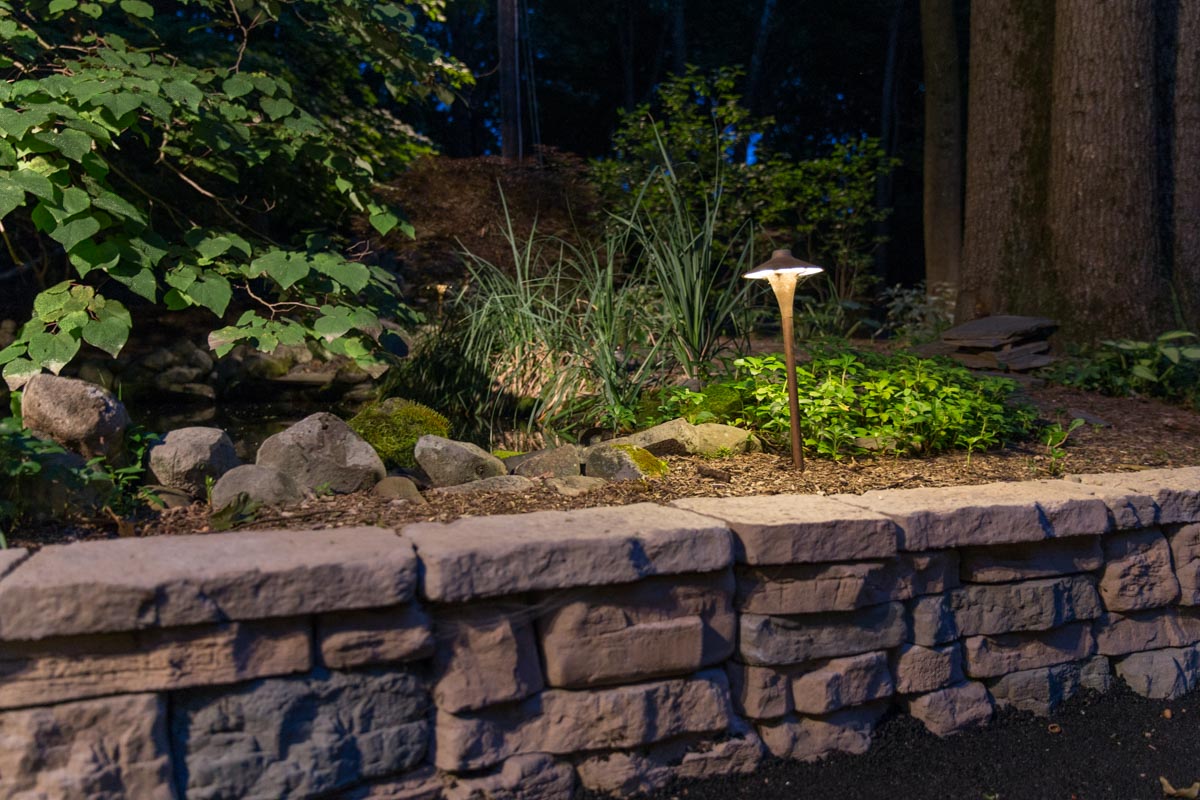 Outdoor path lighting and precast concrete Rosetta Hardscapes retaining wall installed by Masseo Landscape, Inc.